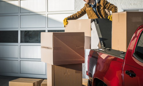 A individual stacking boxes on the back of a truck